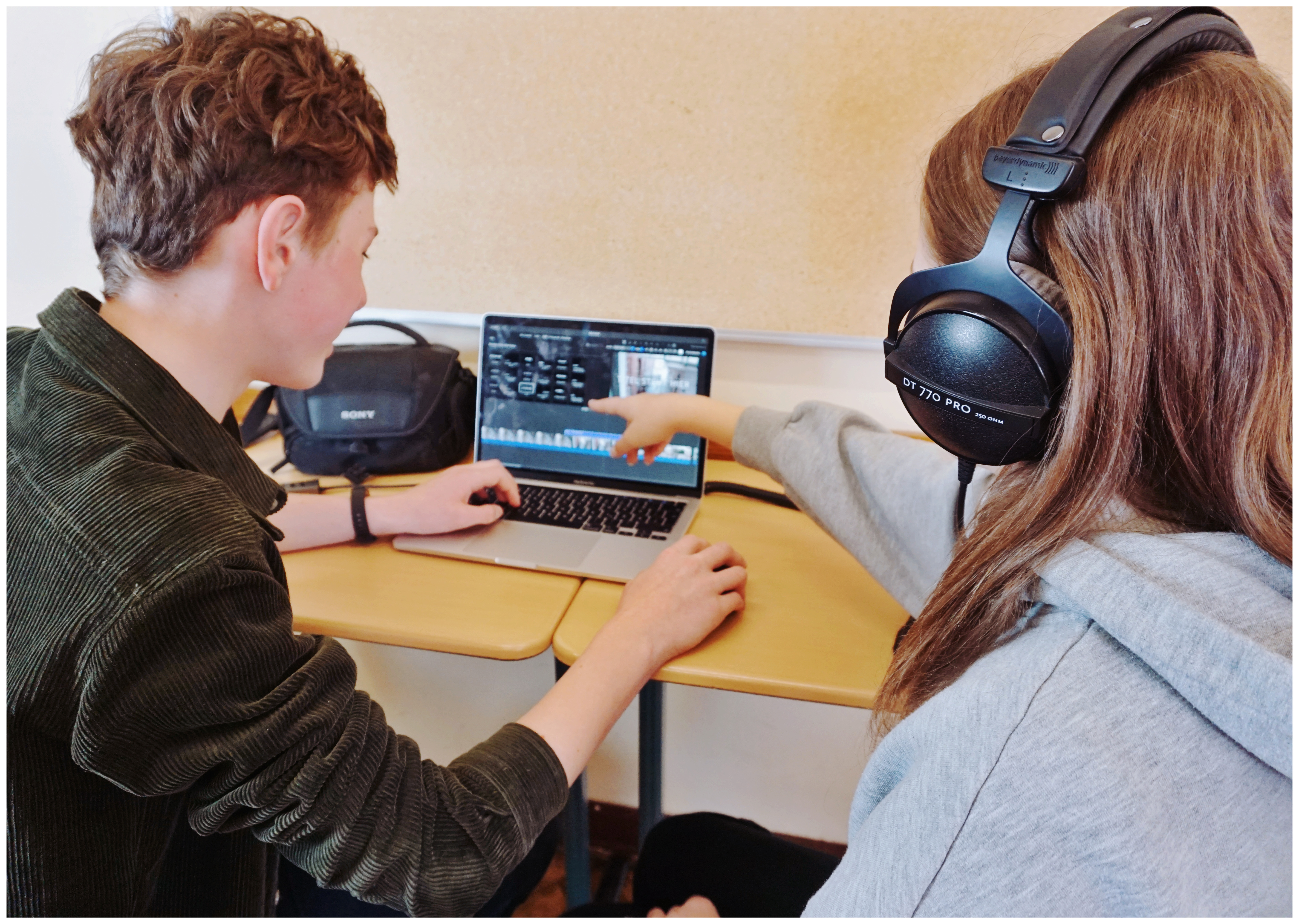 Das Bild zeigt zwei Schüler vor einem Laptop.