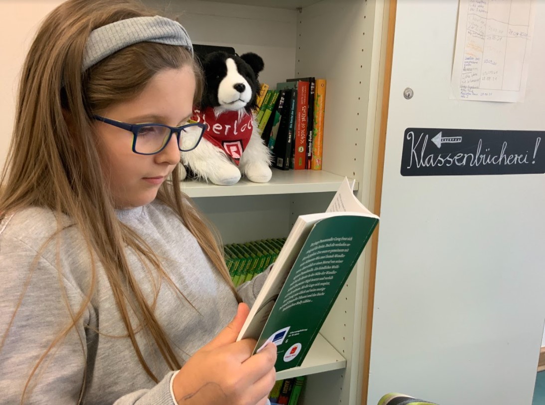 Ein Mädchen liest ein Buch.
